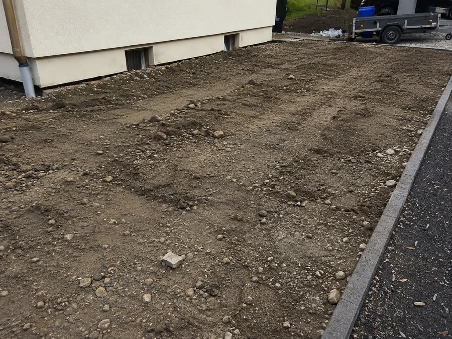 Dieselbe Fläche vor dem Pflastern: unbefestigter Untergrund an der Hauswand